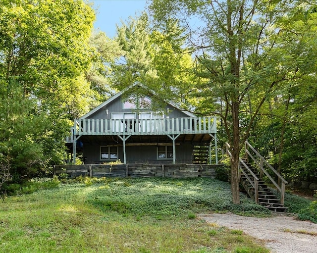 rear view of house featuring a yard and a deck