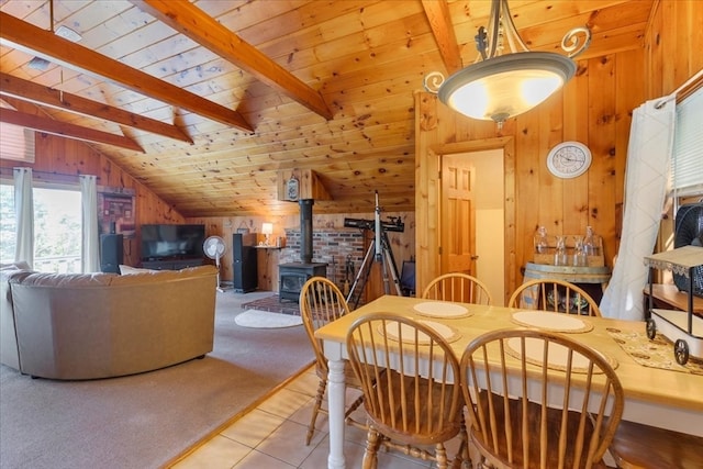 tiled dining room with wood ceiling, a wood stove, lofted ceiling with beams, and wooden walls