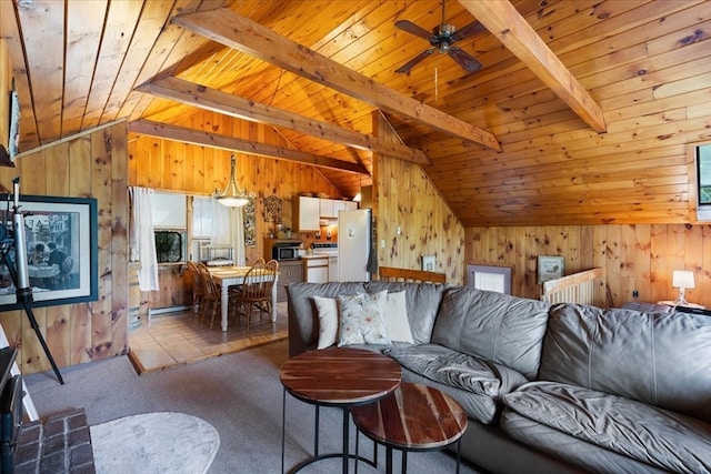 tiled living room with ceiling fan, wooden walls, wooden ceiling, and lofted ceiling with beams