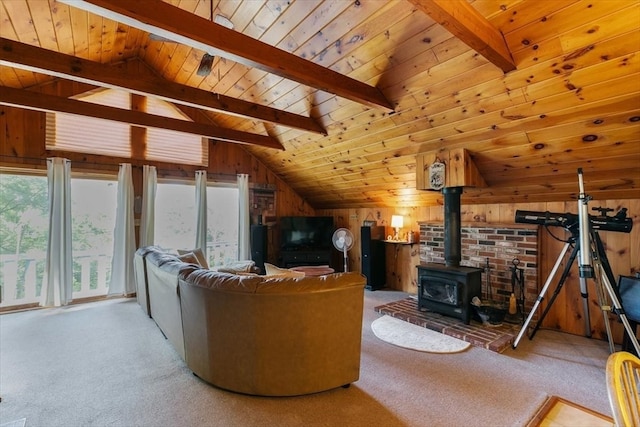 carpeted living room featuring wooden ceiling, lofted ceiling with beams, a wood stove, and wooden walls