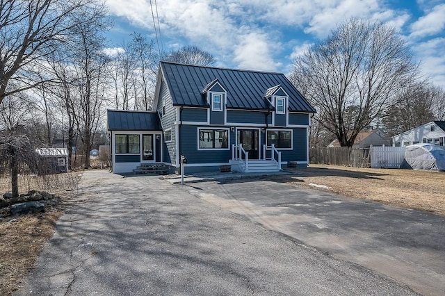 view of front of home featuring metal roof, a standing seam roof, and fence