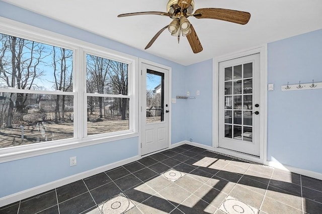 doorway to outside with tile patterned flooring, ceiling fan, and baseboards