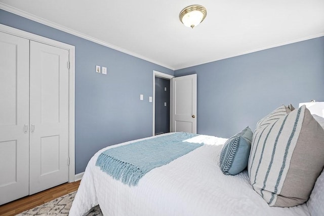 bedroom featuring a closet, wood finished floors, and ornamental molding