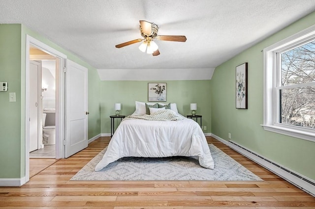 bedroom featuring a textured ceiling, connected bathroom, light wood finished floors, and a baseboard radiator