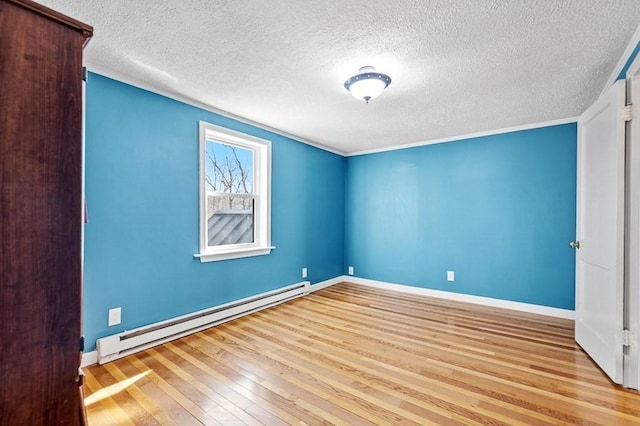 unfurnished room featuring baseboards, baseboard heating, hardwood / wood-style floors, and a textured ceiling