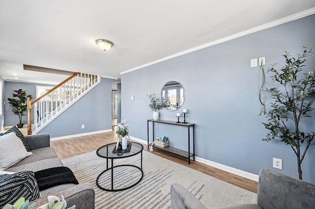 living area featuring wood finished floors, stairs, baseboards, and ornamental molding