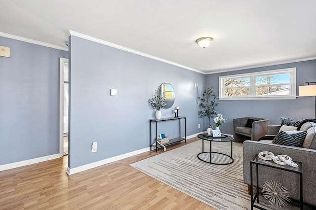 living room featuring light wood finished floors, crown molding, and baseboards