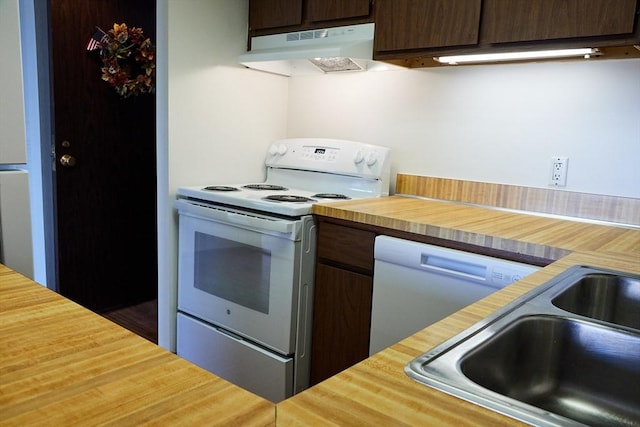 kitchen with dark brown cabinets, sink, and white appliances