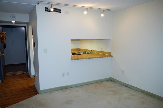 unfurnished room with sink and rail lighting