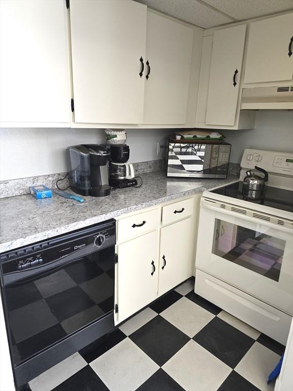 kitchen with a drop ceiling, white cabinets, dishwasher, and white range with electric stovetop