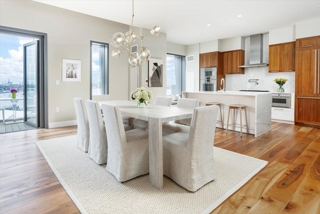 dining area with light hardwood / wood-style flooring, a notable chandelier, and sink