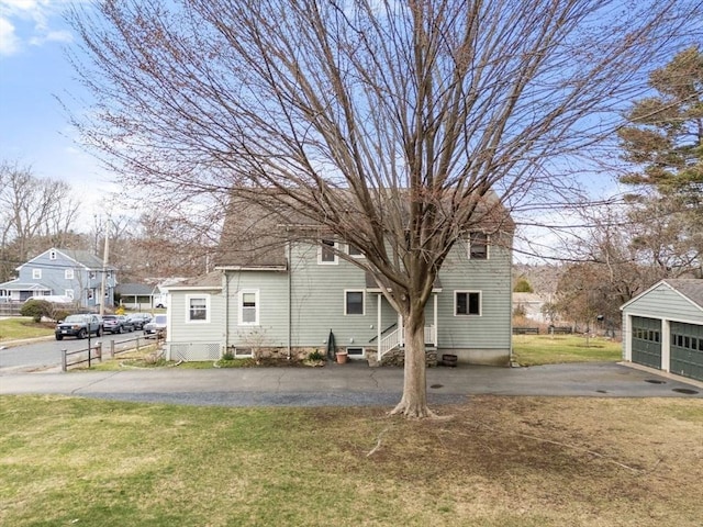 view of front of property with entry steps, an outbuilding, and a front yard