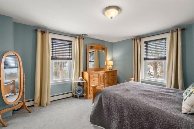 bedroom with visible vents, a baseboard heating unit, and carpet flooring