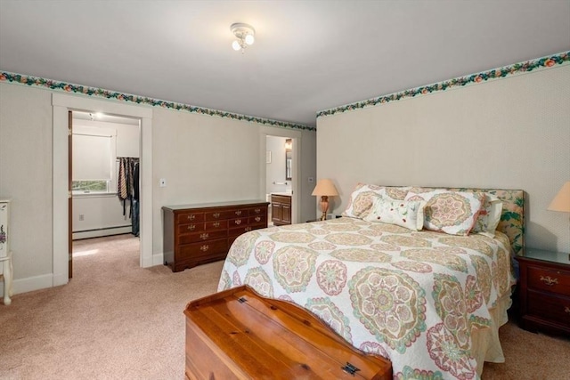 bedroom featuring light carpet, baseboards, ensuite bathroom, and baseboard heating