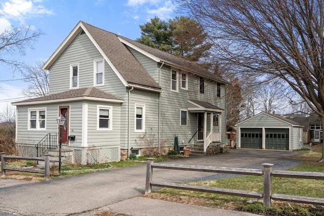 view of front of house with an outdoor structure, a garage, fence private yard, and a shingled roof