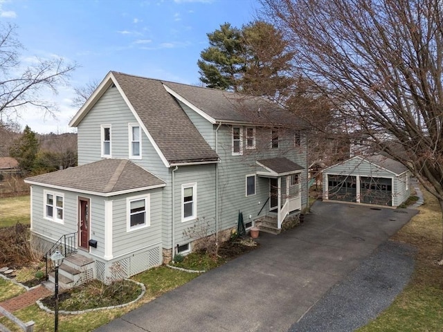 view of front of home with a garage, an outbuilding, and a shingled roof
