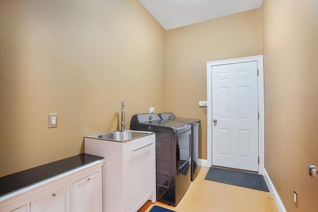 laundry area featuring cabinets, washing machine and dryer, sink, and light colored carpet