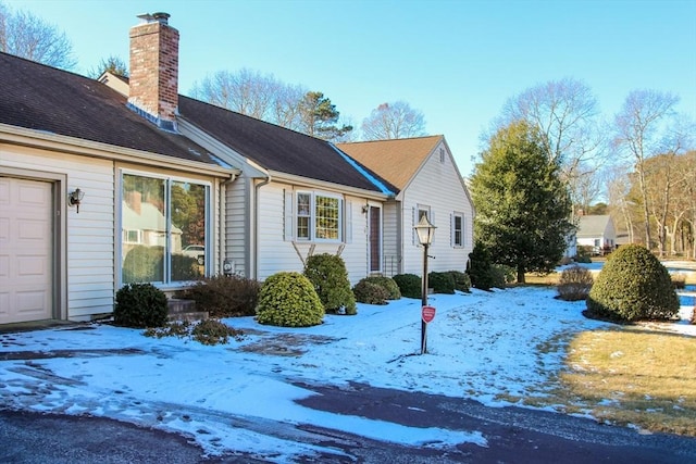 view of snow covered exterior featuring a garage