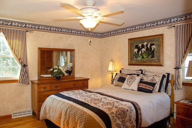 bedroom with ceiling fan and light wood-type flooring