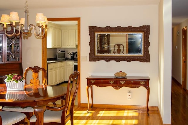 dining space with a chandelier and light hardwood / wood-style floors