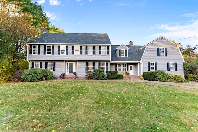 colonial-style house featuring a front lawn