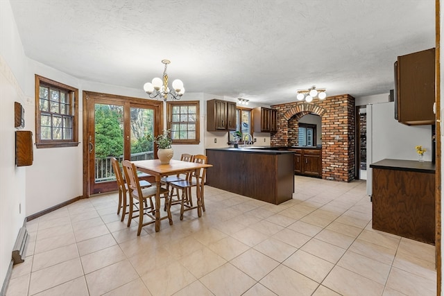 dining room with an inviting chandelier, a textured ceiling, and light tile patterned floors