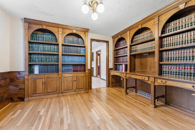 office space with light hardwood / wood-style floors, a notable chandelier, and a textured ceiling