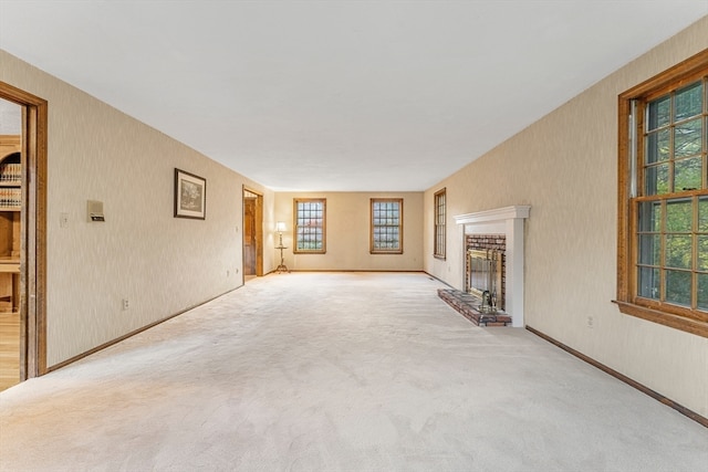 unfurnished living room featuring light carpet, a fireplace, and plenty of natural light