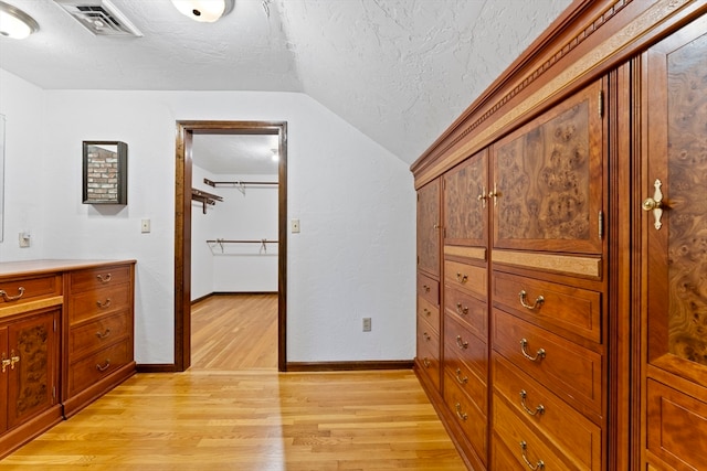 interior space with vaulted ceiling and light wood-type flooring