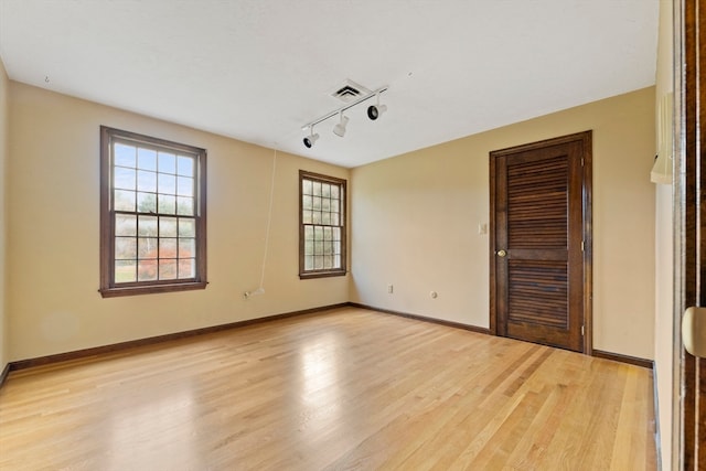 spare room with track lighting and light hardwood / wood-style flooring