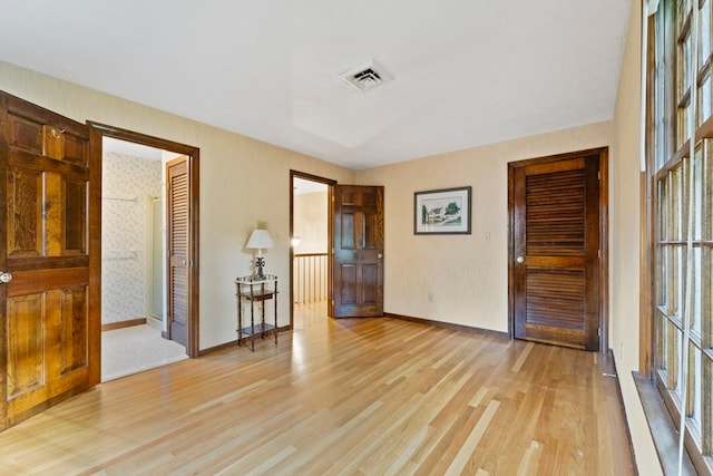 unfurnished room featuring a wealth of natural light and light hardwood / wood-style floors