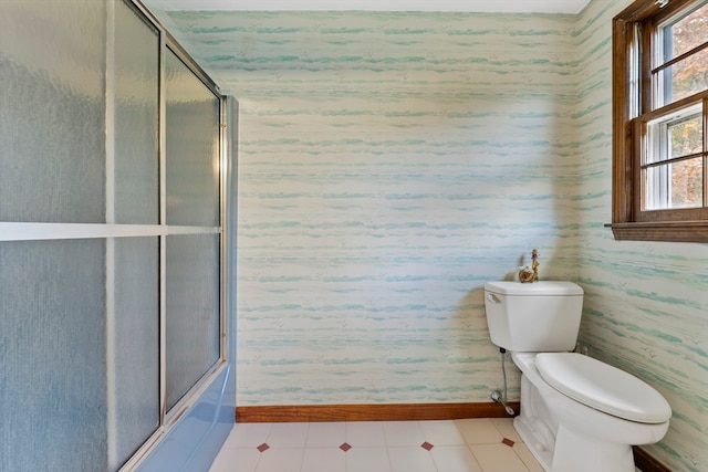 bathroom with bath / shower combo with glass door and toilet