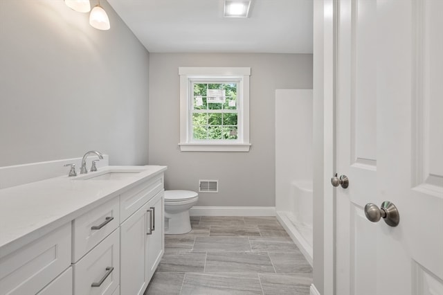 bathroom with vanity, toilet, and walk in shower