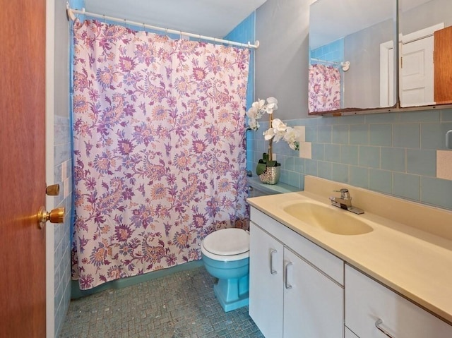 bathroom featuring tile patterned floors, vanity, toilet, and tile walls