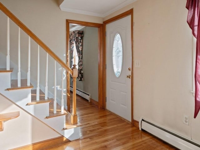 entryway featuring baseboard heating, crown molding, and light hardwood / wood-style floors