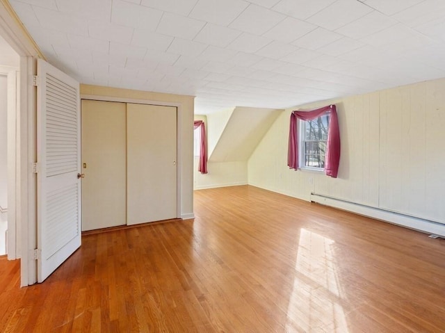 additional living space with a baseboard radiator and hardwood / wood-style flooring