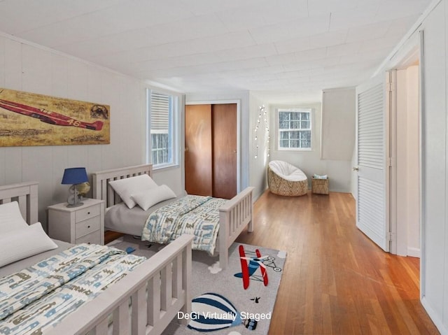 bedroom with light hardwood / wood-style floors and multiple windows