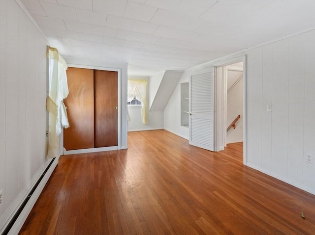 bonus room featuring hardwood / wood-style floors and a baseboard heating unit