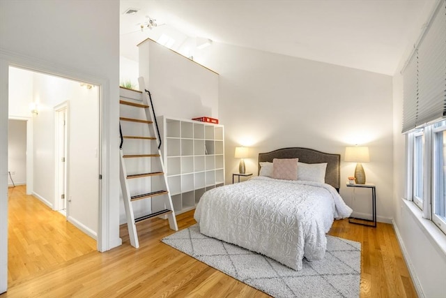 bedroom with hardwood / wood-style flooring and lofted ceiling