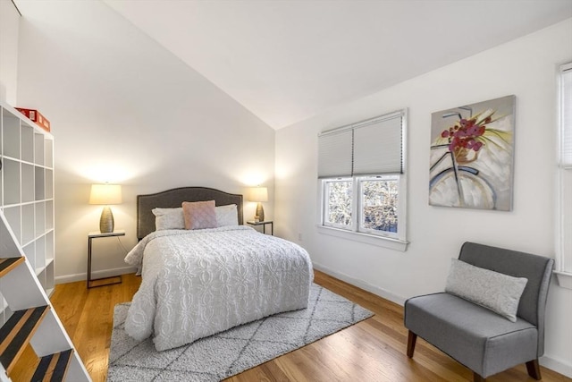 bedroom featuring lofted ceiling and light wood-type flooring