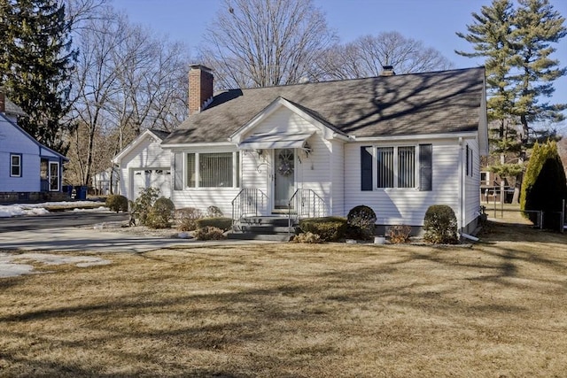 view of front of home featuring a garage, a chimney, and a front lawn