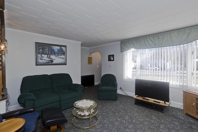 living area featuring crown molding, carpet, arched walkways, and baseboards