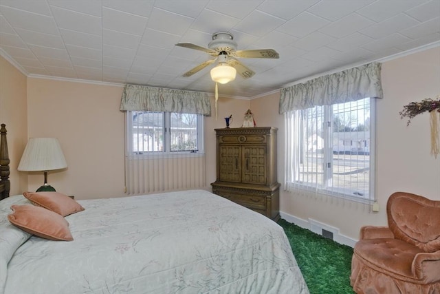 carpeted bedroom featuring visible vents, baseboards, crown molding, and ceiling fan