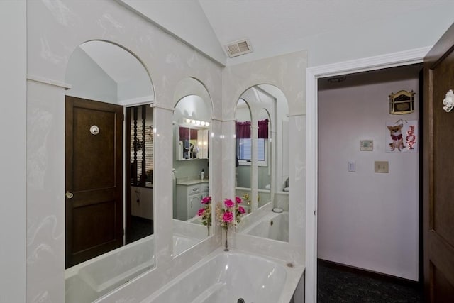 bathroom with visible vents, lofted ceiling, and a whirlpool tub