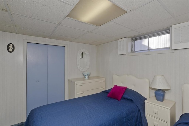 bedroom with a closet and a paneled ceiling