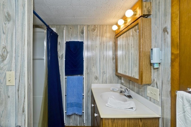 bathroom featuring vanity and wood walls