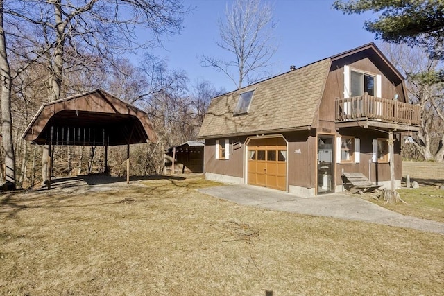 view of side of home featuring a gambrel roof, driveway, roof with shingles, a garage, and a carport