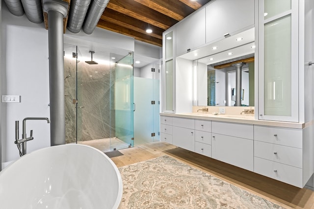 bathroom featuring vanity, separate shower and tub, beamed ceiling, and wood-type flooring