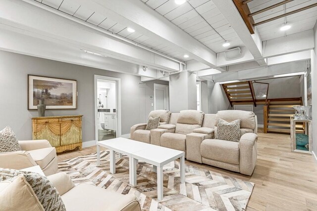 living room featuring beamed ceiling and light hardwood / wood-style flooring