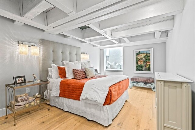 bedroom featuring light hardwood / wood-style flooring, coffered ceiling, and beamed ceiling